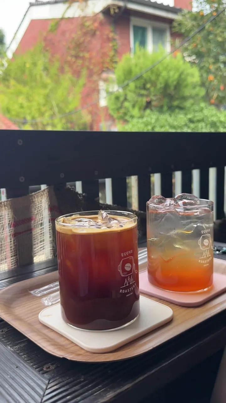 Iced Americano and plum ade on a wooden windowsill at Dongsung-dong Coffee