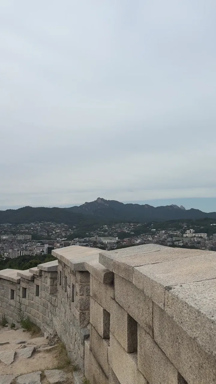 Seoul City Wall at Naksan Park with neighborhoods and mountains beyond